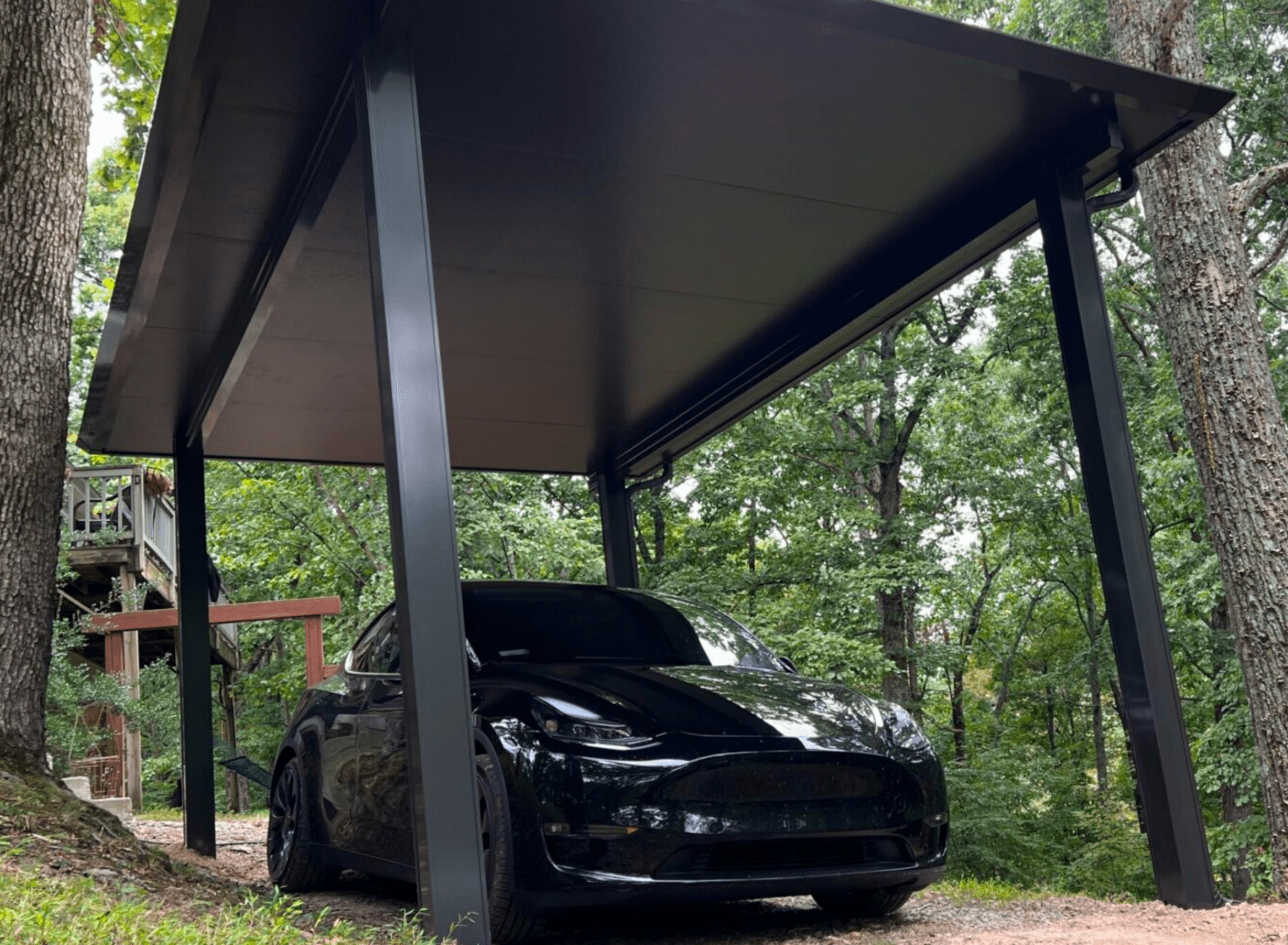 A black car under a covered parking lot.
