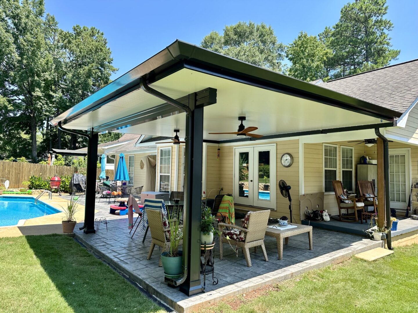 Backyard patio with pool and seating area.
