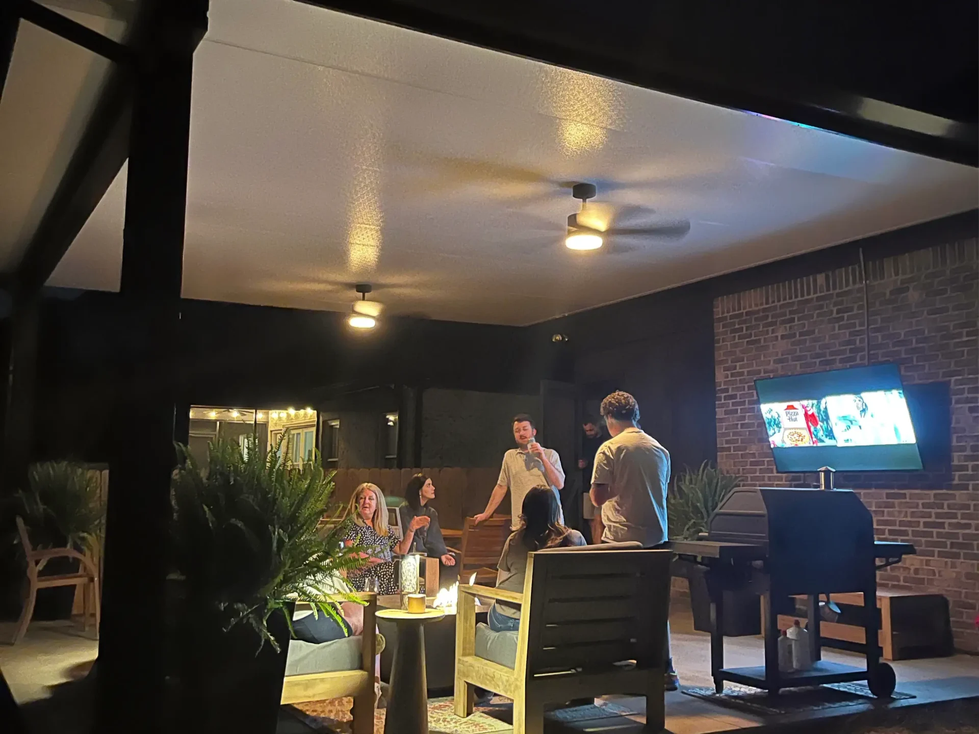 People relaxing on a patio at night.