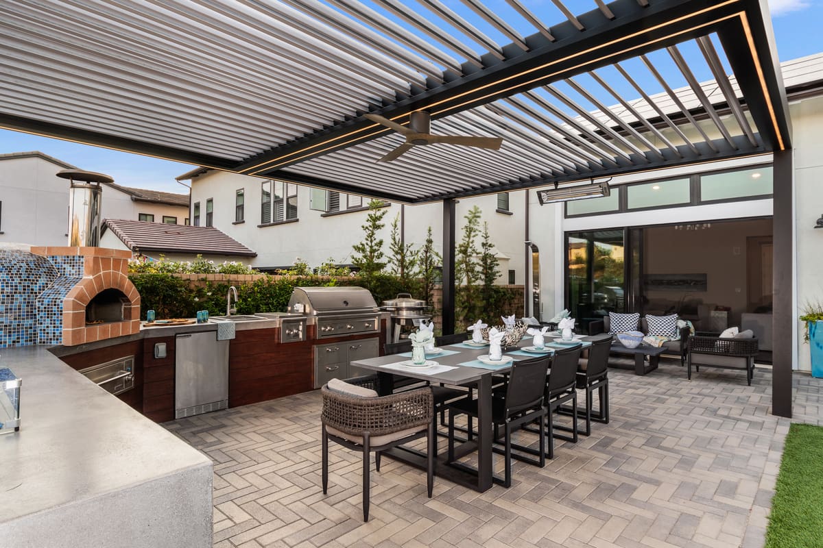 Outdoor kitchen and dining area under pergola