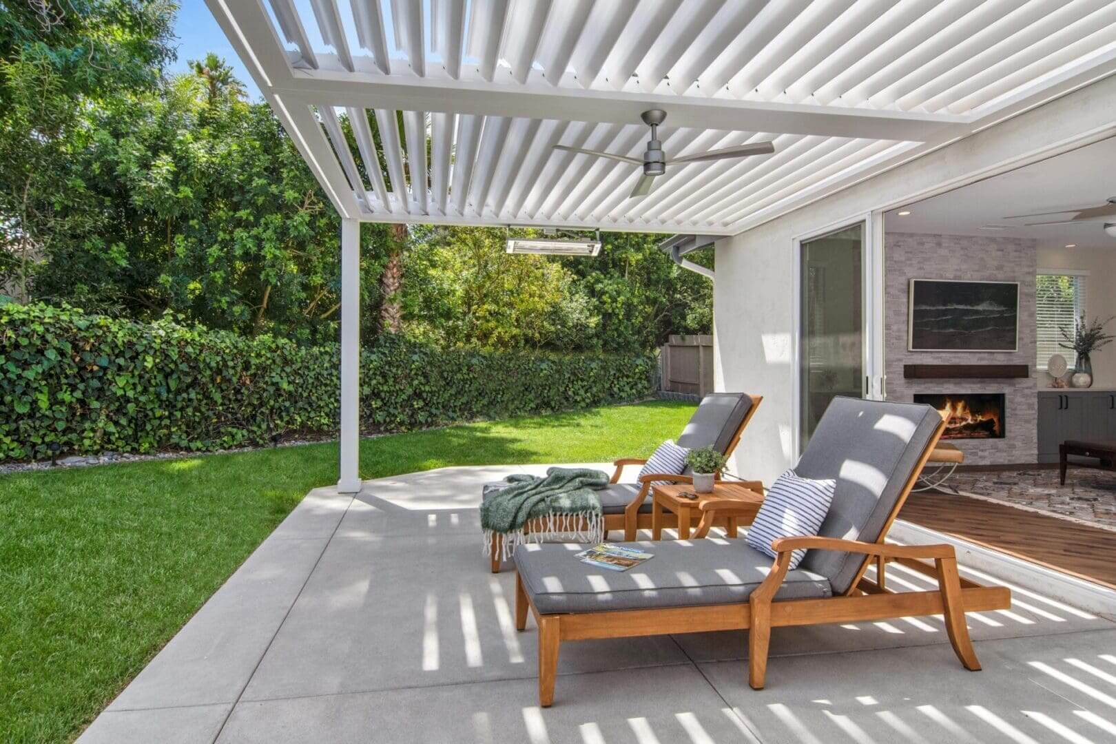 Pergola shaded backyard patio with lounge chairs