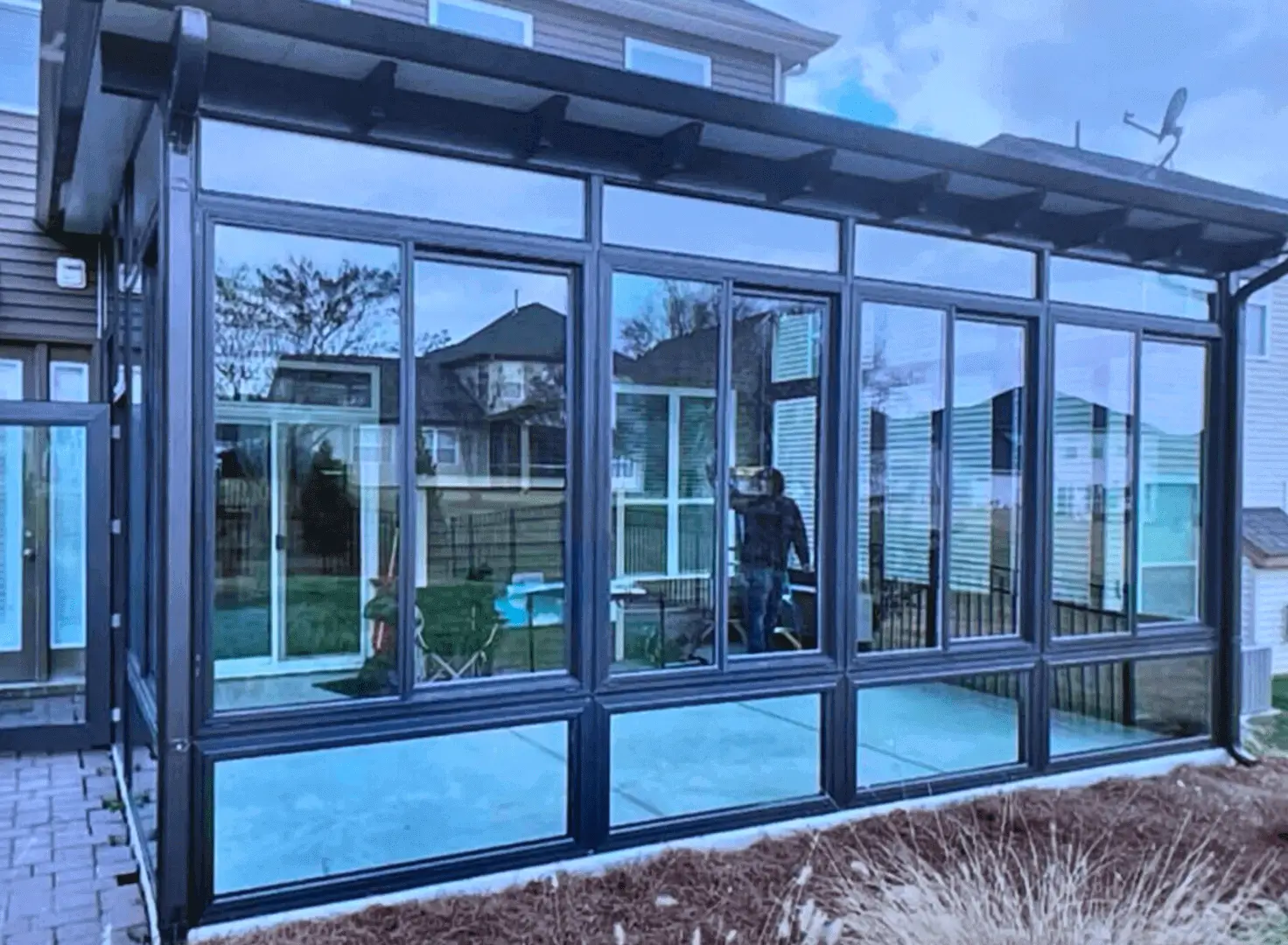 Modern glass enclosed sunroom with black frames